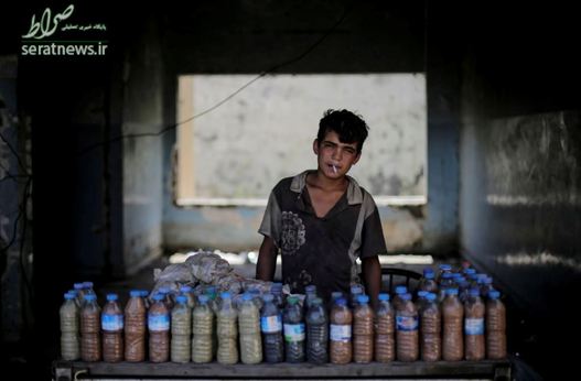 عبدالعزیز 15 ساله با سیگاری در دهان به مشتریان خود برای حمام کردن گوگرد می فروشد - حمام القلیل، جنوب موصل
