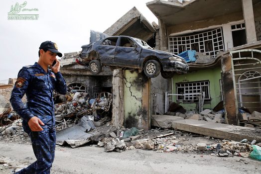 افسر عراقی در حال عبور از خانه ویران ویران شده در موصل