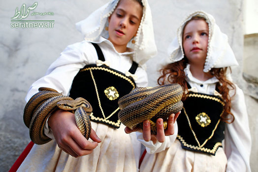 یک دختر با دو ما در دست در جریان برگزاری یک مراسم در منطقه کوکولوی ایتالیا