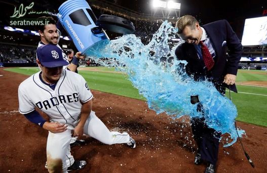 لحظه ریختن نوشیدنی انرژی زا بر روی توسط یک بازیکن بیسبال بر روی هم تیمی خود - کالیفرنیا، آمریکا