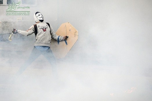 یک مخالف دولت ونزوئلا در حال پرتاب کوکتل مولوتف به سوی نیروهای پلیس ضد شورش در کاراکاس