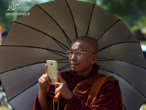 یک افراطی بودایی در میانمار در حال عکس گرفتن با موبایل خود در طول برگزاری یک تظاهرات