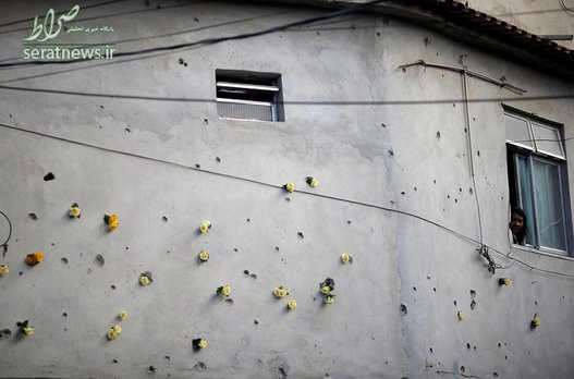 تزئین دیوارهای خانه ای در محله فقیرنشین ریودوژانیرو با گل که در عملیات پلیس علیه باندهای مواد مخدر آسیب دیده