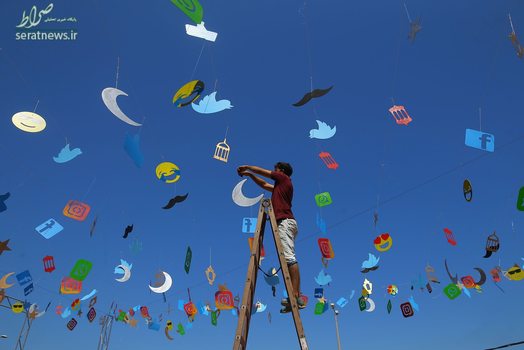 هنرمند فلسطینی در حال آذین بندی یک کافه در روز قبل از آغاز ماه مبارک رمضان در غزه