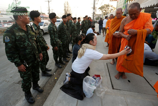 راهبان بودایی در حال دریافت غذا و تنقلات از مردم در استان پاتوم ثانی تایلند