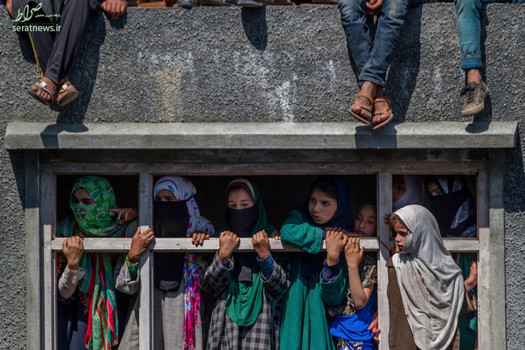 دختران کشمیری در حال تماشای تشییع جنازه یکی از رهبران جدایی طلب در سرینگر هند