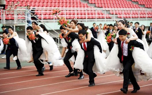 کولی سواری عروس خانم ها از آقا دامادها در جریان برگزاری مراسم عروسی دسته جمعی 64 زوج دانشجوی دکترا در شهر هاربین چین