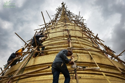 کارگران در حال تعمیر یک معبد طلایی در بانکوک تایلند