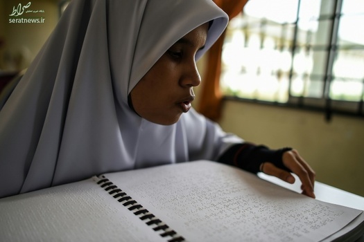 یک دختر نابینا در مالزی در حال خواندن قرآن به خط بریل