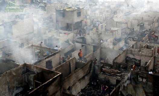  تصویری از ساکنان شهر «ماکاتی» فیلیپین که در ویرانه‌های خانه‌هایشان که در آتش‌ سوخته‌ ایستاده‌اند (آوریل ۲۰۱۱) 