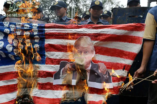 معترضان در طول یک تظاهرات مقابل سفارت آمریکا در مانیل فیلیپین عکس ترامپ و پرچم آمریکا را با هم به آتش کشیدند