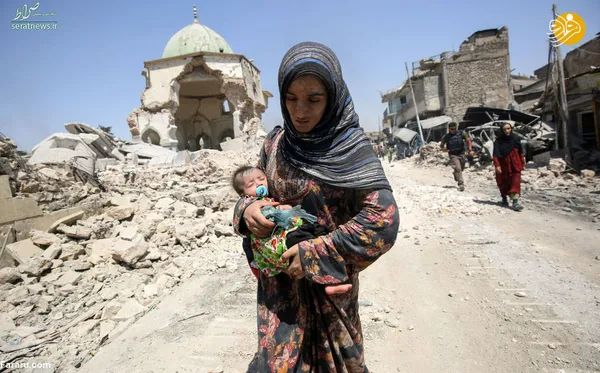 زن عراقی همراه با کودک خود در شهر موصل، عراق
