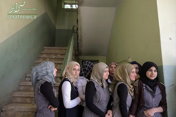 دختران دانش آموز عراقی ایستاده مقابل یک کلاس در مدرسه ابتدایی شرق موصل