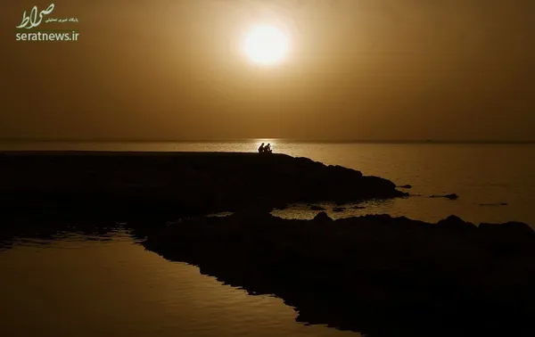 زن و شوهر نشسته در کنار ساحل در غروب آفتاب - پافوس، قبرس