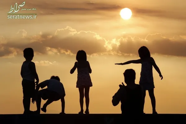کودکان ایستاده کنار یک ساحل در غروب آفتاب - مانیل، فیلیپین
